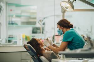 woman getting work done on her teeth at the dentist