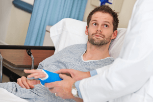 man with cast on in a hospital bed