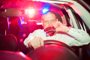 man having a drink while driving