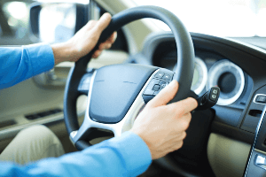 man grasping a steering wheel with both hands