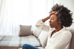 stock img of young black woman looking tired