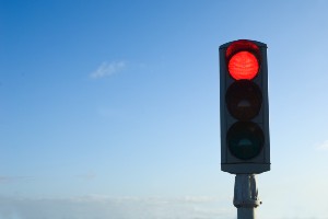 image of red traffic light signal against blue sky