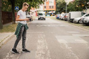 teenage-boy-crossing-street-cell-phone
