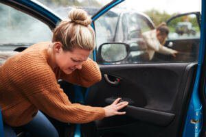 blonde-woman-holding-neck-getting-out-car